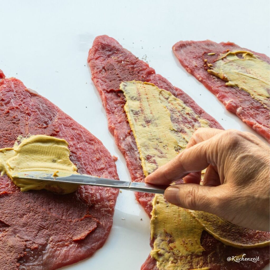 Rindschnitzel mit Senf bestreichen