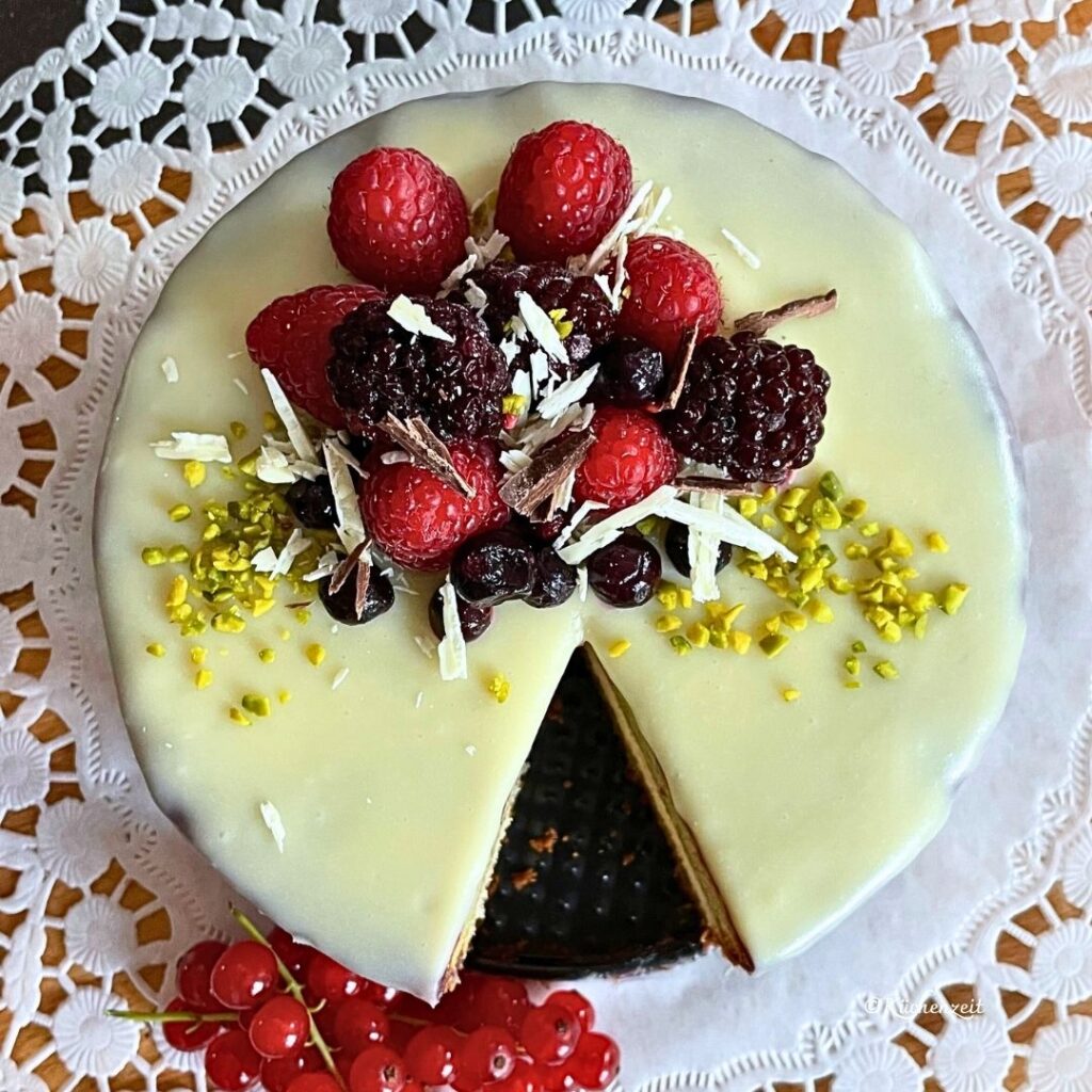 weiße Schokoladetorte mit roten Beeren garnieren